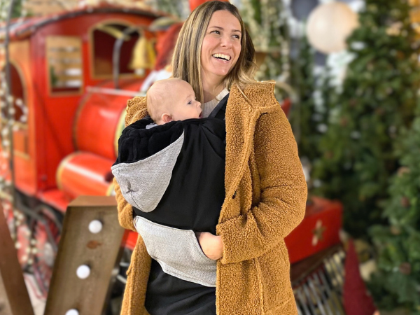 Parent carrying a child protected by the BabyMonkey Winter Cover