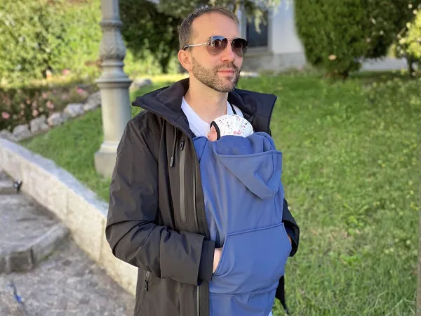 Parent carrying a child protected by the BabyMonkey Mid-Season Cover