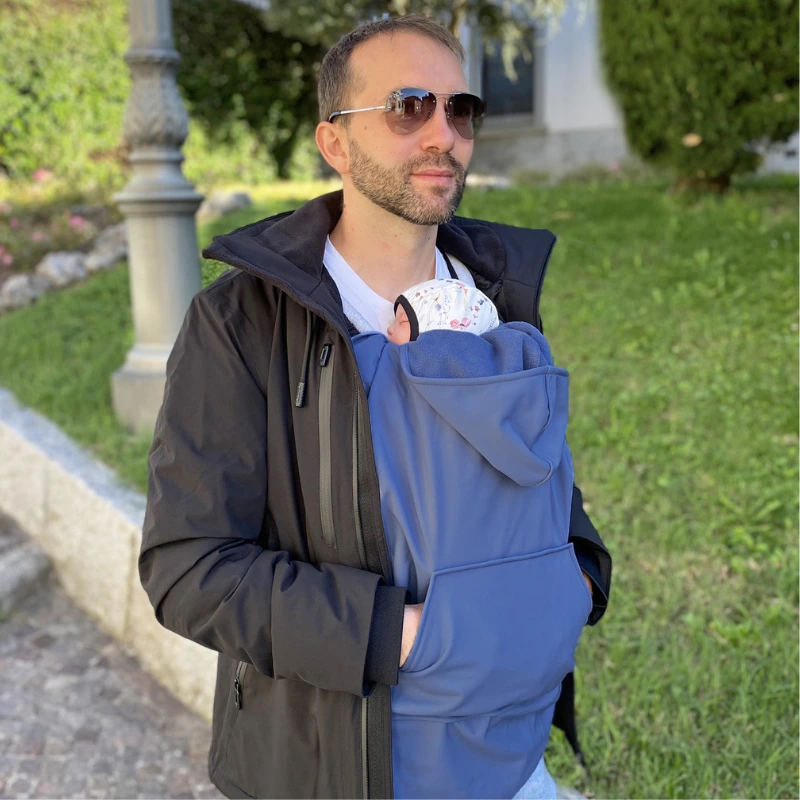 Genitore con marsupio ergonomico in città in inverno