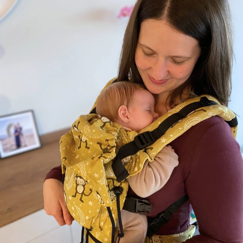 Bambino che dorme nel marsupio in inverno